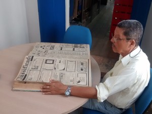 Frequentador assíduo da biblioteca observa jornais da década de 50 (Foto: Shade Andréa/G1)
